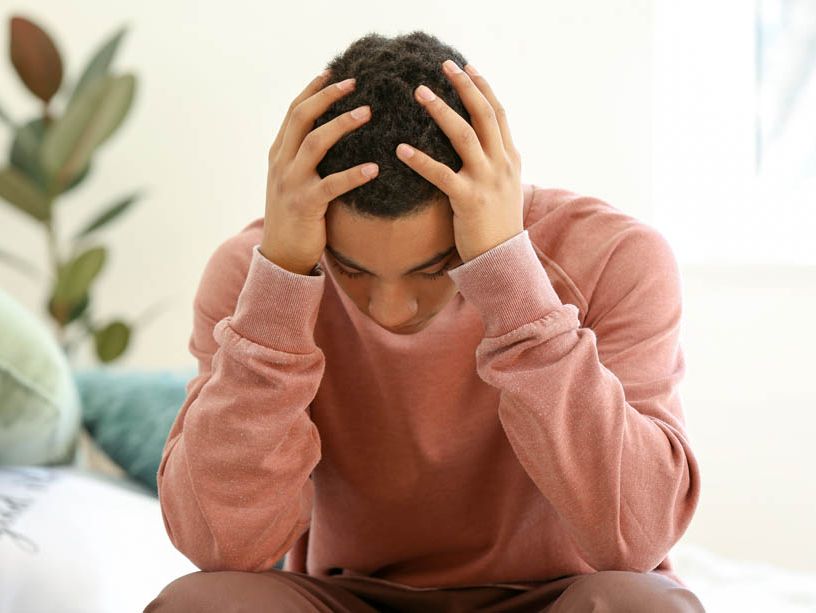 Junge hält seinen Kopf